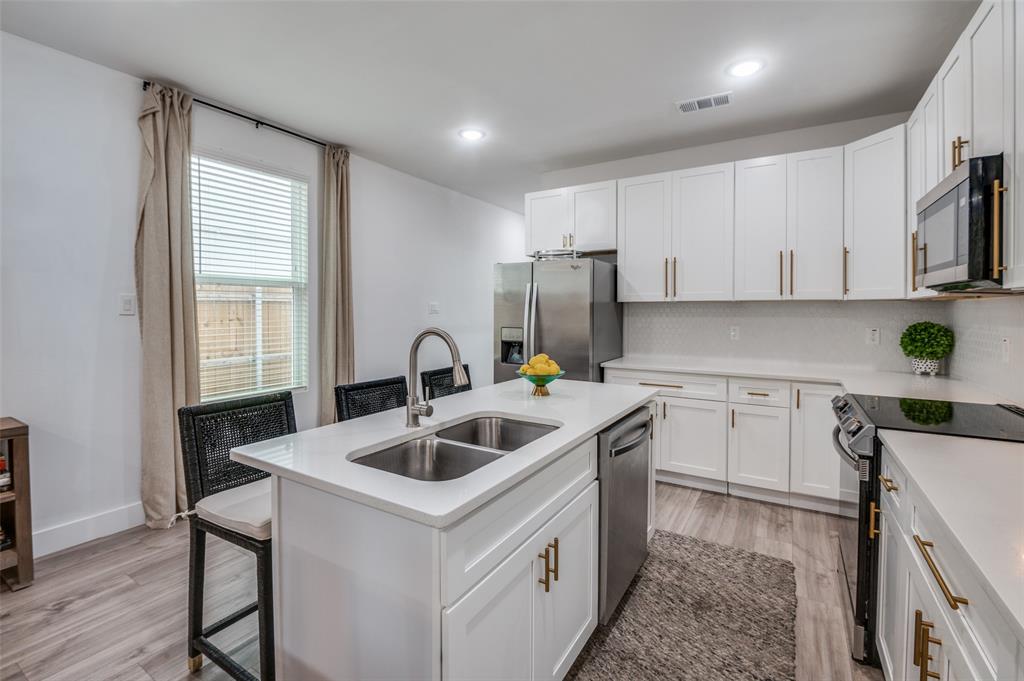 2325 Budd Street Dallas, TX 75215 - Photo 4 of 12 a kitchen with a stove a sink and a microwave