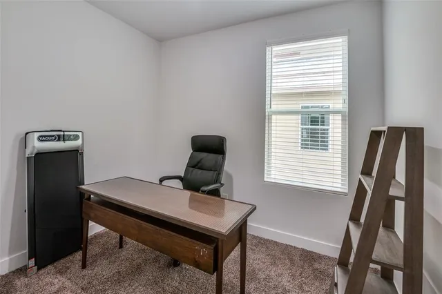 a view of a workspace with furniture and a window