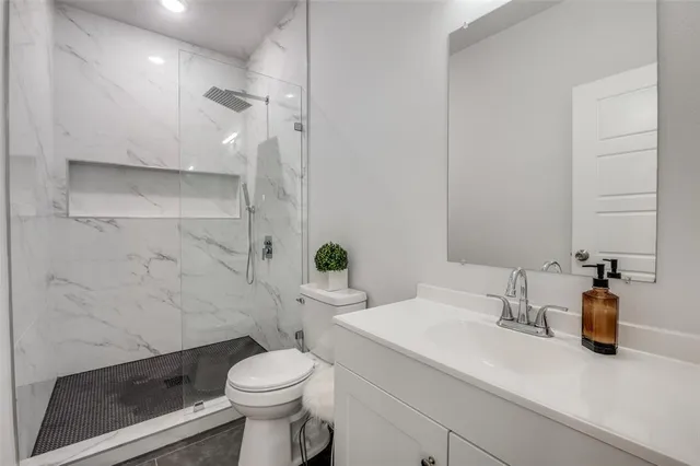 a bathroom with a sink a toilet and shower