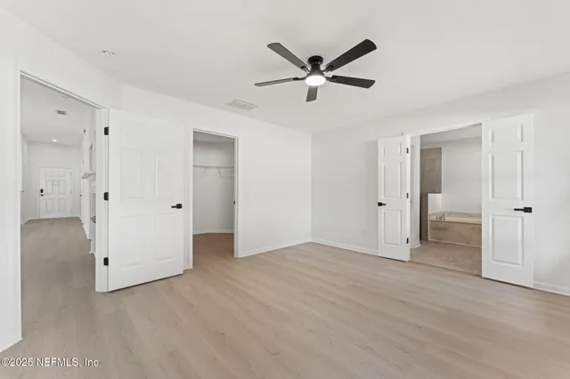 a view of empty room with wooden floor and window