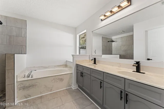 a bathroom with a tub a sink and mirror