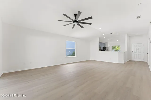 a view of a livingroom with a ceiling fan and wooden floor