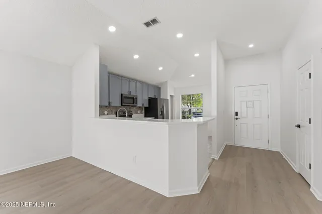 a view of a kitchen and an empty room