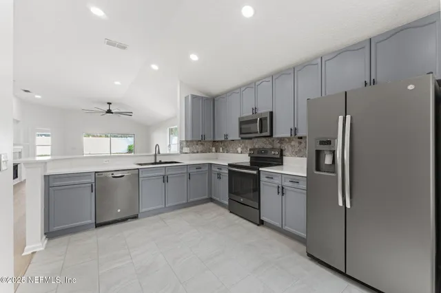 a kitchen with a refrigerator stove top oven and sink