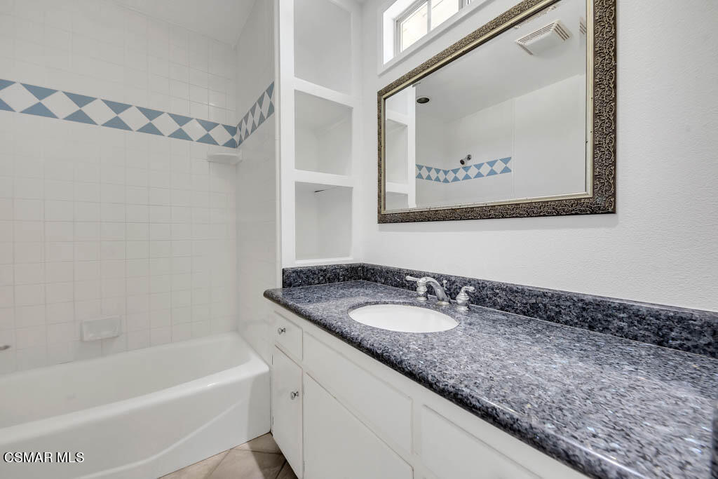 2039 Madrone Street Simi Valley, CA 93065 - Photo 20 of 35 a bathroom with a granite countertop sink a mirror a bathtub and shower