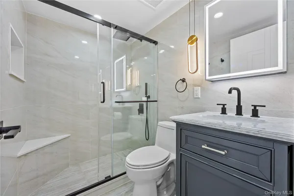 a bathroom with a granite countertop sink toilet and shower