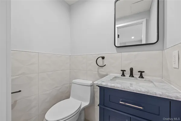 a bathroom with a granite countertop toilet sink and mirror