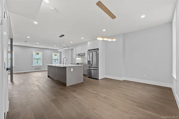a large kitchen with a lot of counter space and wooden floor