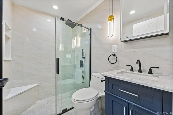 a bathroom with a granite countertop sink toilet and shower