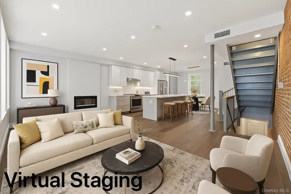 a living room with furniture and a view of kitchen