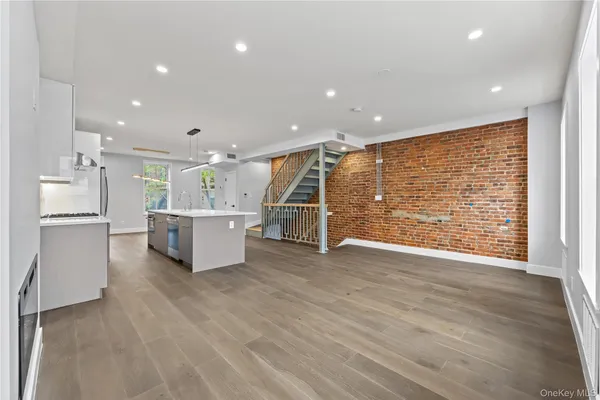 a open kitchen with white cabinets and wooden floor