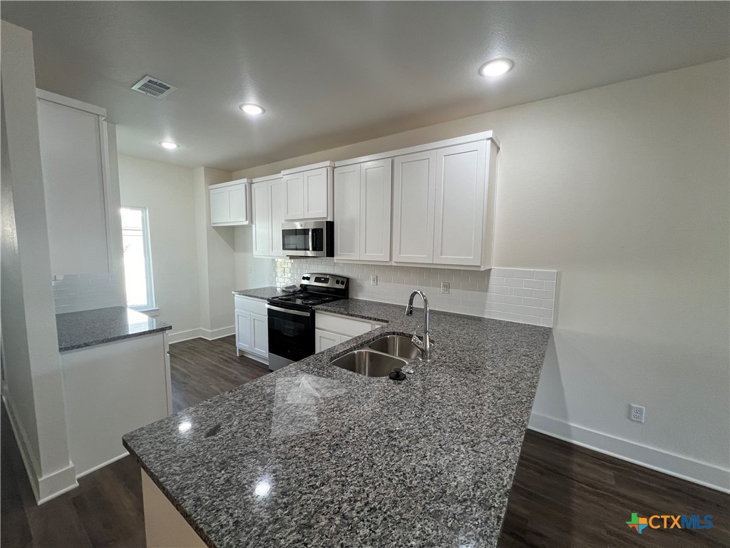 1814 Royal Loop Belton, TX 76513 - Photo 4 of 15 a kitchen with stainless steel appliances granite countertop a sink a stove and a microwave