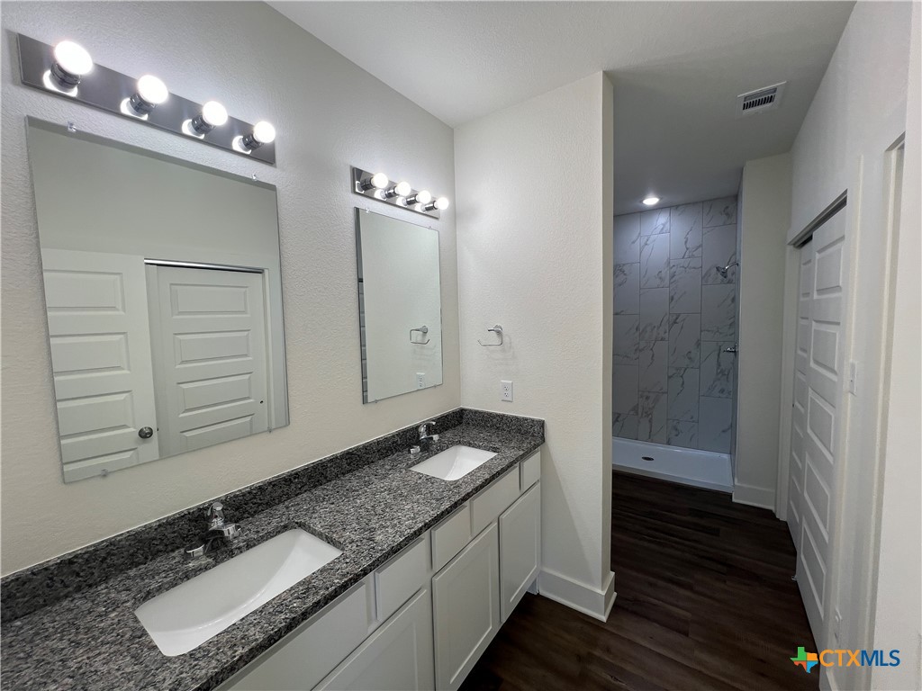 1814 Royal Loop Belton, TX 76513 - Photo 7 of 15 a bathroom with a granite countertop sink a light fixture and a mirror