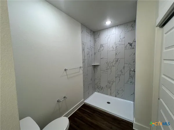 a bathroom with a toilet a sink and shower