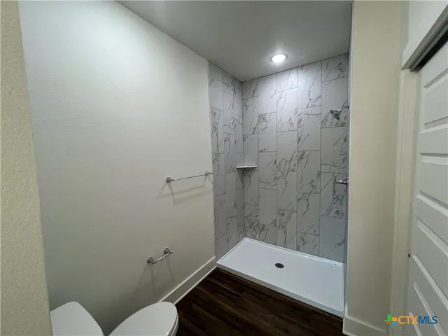 a bathroom with a toilet a sink and shower