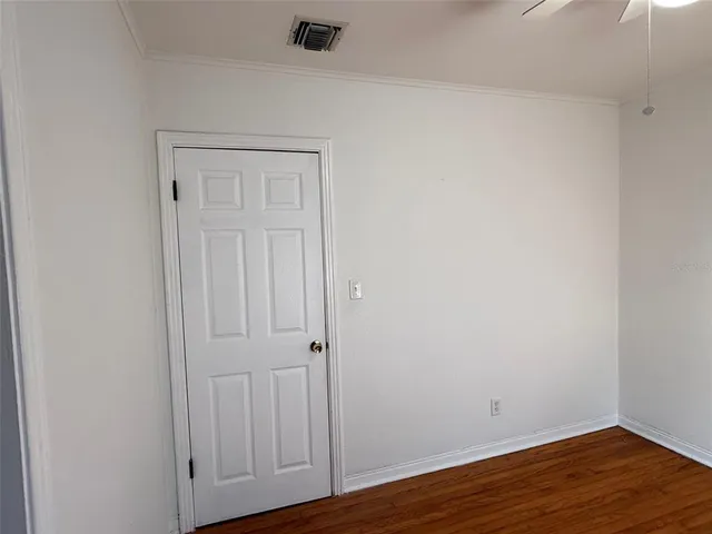 a view of an empty room with wooden floor