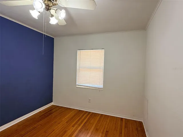 an empty room with a window and wooden floor