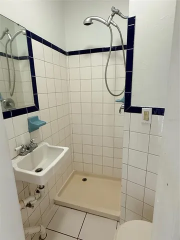 a bathroom with a sink a shower and a mirror
