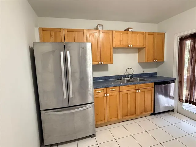 a kitchen with stainless steel appliances granite countertop a refrigerator a sink and a refrigerator