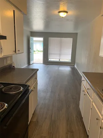 a kitchen with granite countertop a sink stove and refrigerator