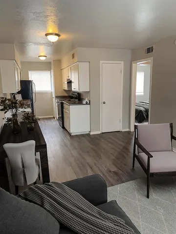 a living room with furniture and kitchen view