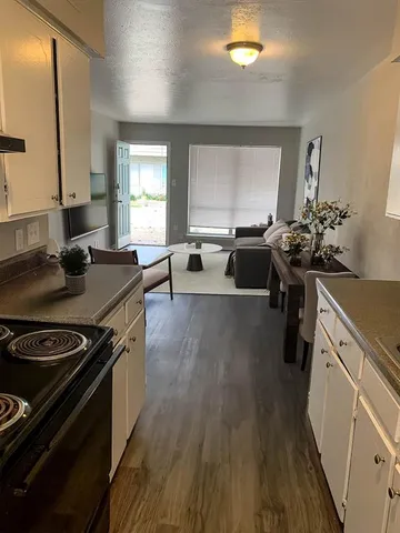a kitchen with a stove and a wooden floor