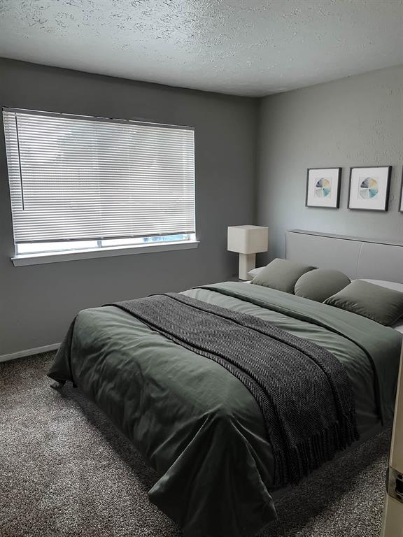 4606 Monarch Street, Unit 109 Dallas, TX 75204 - Photo 7 of 17 Bedroom featuring a textured ceiling and carpet