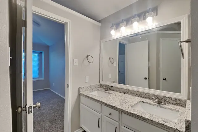 a bathroom with a granite countertop sink and a mirror