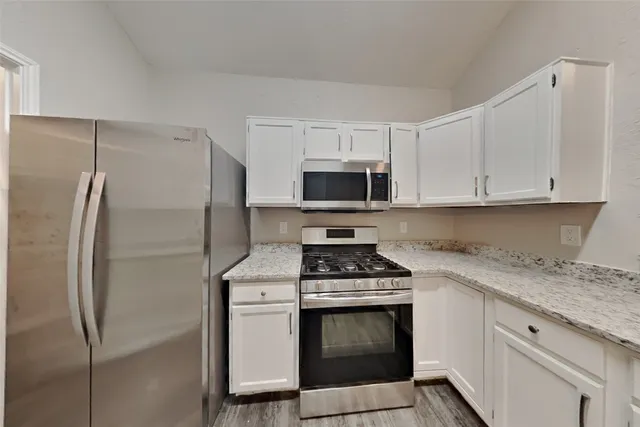 a kitchen with cabinets stainless steel appliances and a counter space