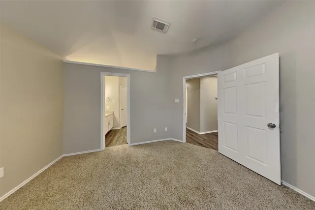 a view of an empty room with window and closet area