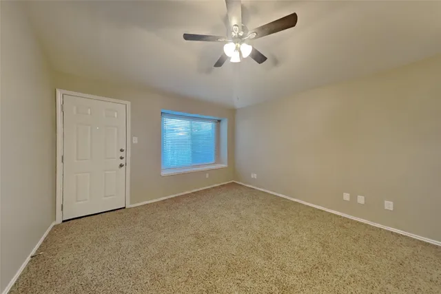 an empty room with chandelier fan