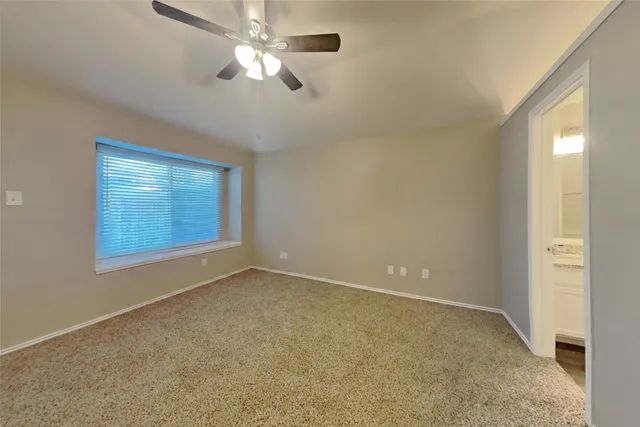 en empty room with windows and fan