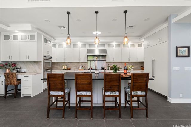a kitchen with kitchen island a dining table and chairs in it