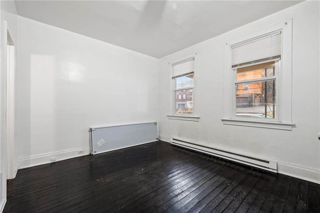 902 Robinson Street McKees Rocks, PA 15136 - Photo 12 of 31 an empty room with wooden floor and windows