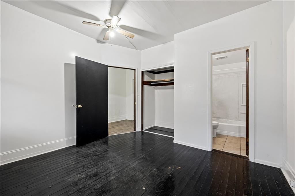 902 Robinson Street McKees Rocks, PA 15136 - Photo 13 of 31 an empty room with wooden floor a ceiling fan and closet