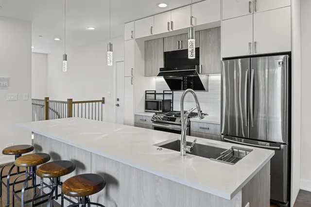 a kitchen with stainless steel appliances granite countertop a sink a stove and a refrigerator