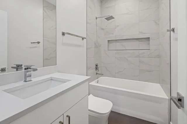 a bathroom with a sink toilet vanity and shower