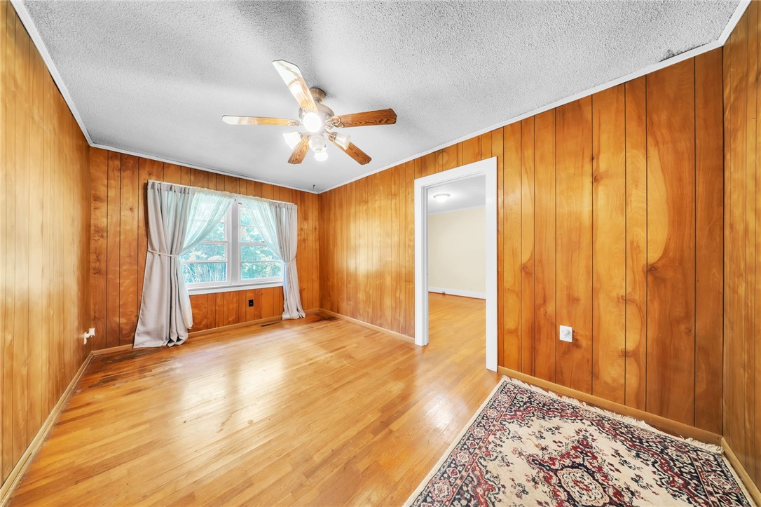 107 Burton Road Anderson, SC 29625 - Photo 9 of 33 Warm wood paneling and matching hardwood floors define this classic living space.