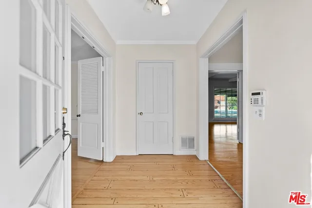 a view of empty room with wooden floor and fan