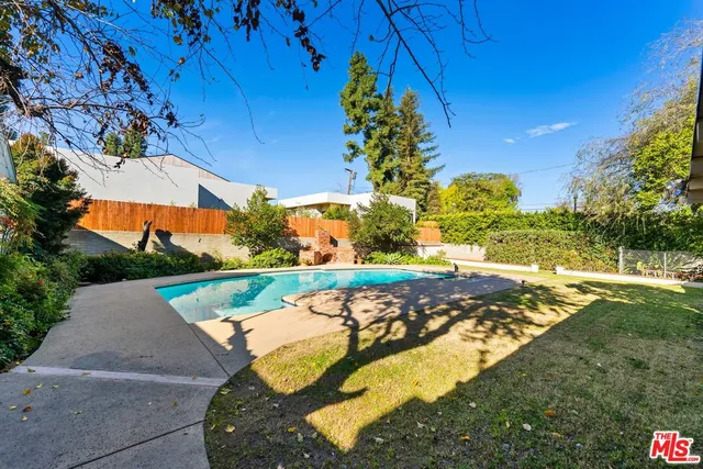 an aerial view of a house with swimming pool and outdoor seating