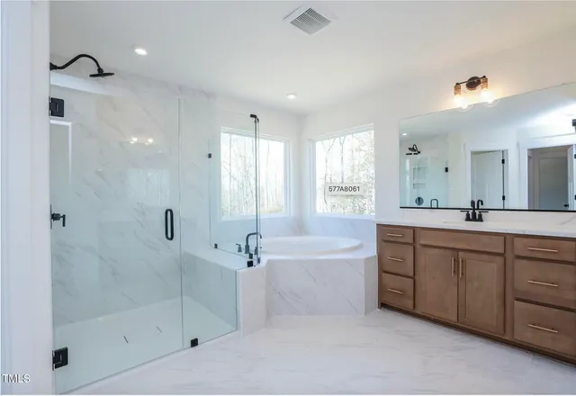 a spacious bathroom with a bathtub shower sink and mirror