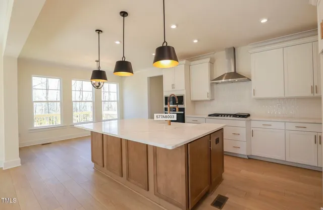 a kitchen with counter top space sink stove and wooden floor
