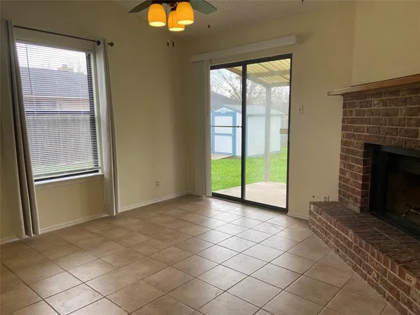 a view of an empty room with window and fire place