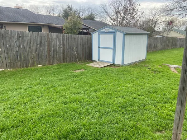 a view of a backyard with potted plants and wooden fence