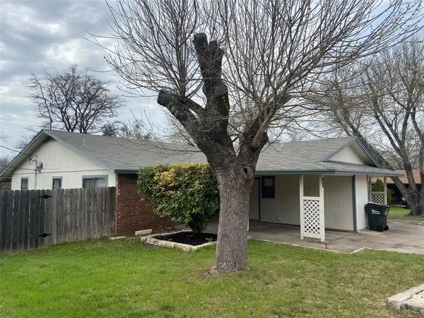 a view of a yard in front of a house with large tree