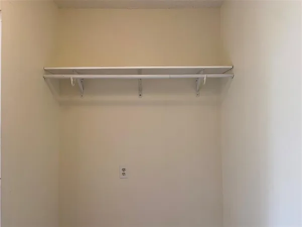 a view of a closet with racks on the wall