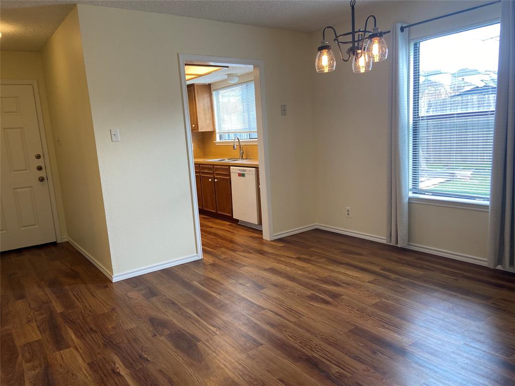 12800 Old San Antonio Road, Unit A Manchaca, TX 78652 - Photo 5 of 38 an empty room with wooden floor chandelier and windows