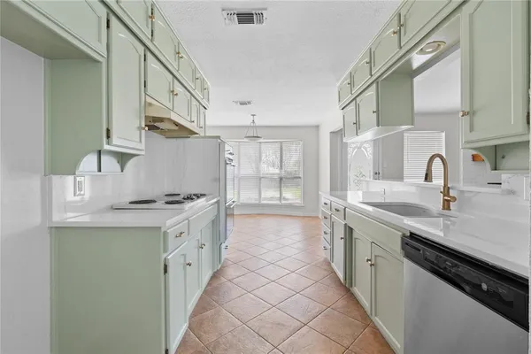 a kitchen with stainless steel appliances granite countertop a sink and dishwasher with white cabinets