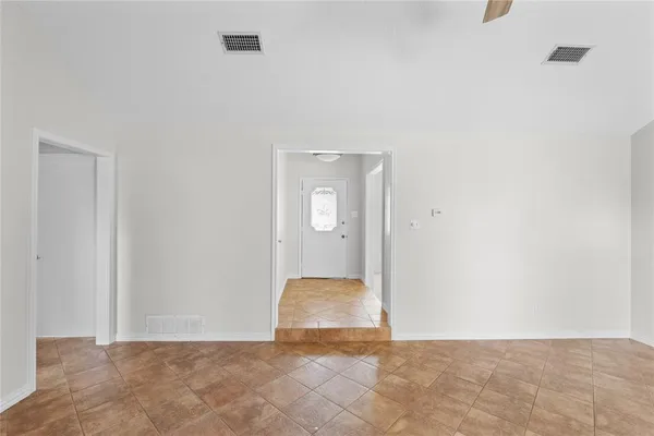 an empty room with windows and fireplace