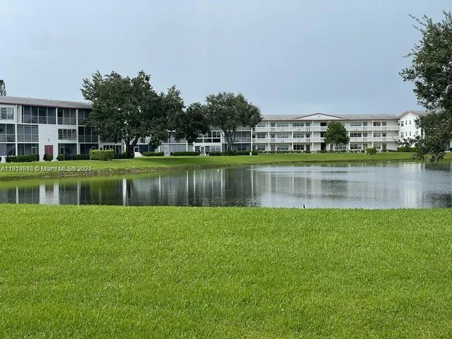 a view of a house with a yard and a pond